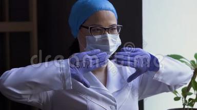 漂亮的女科学家戴着口罩，戴着医用手套，竖起大拇指。 成功接种疫苗
